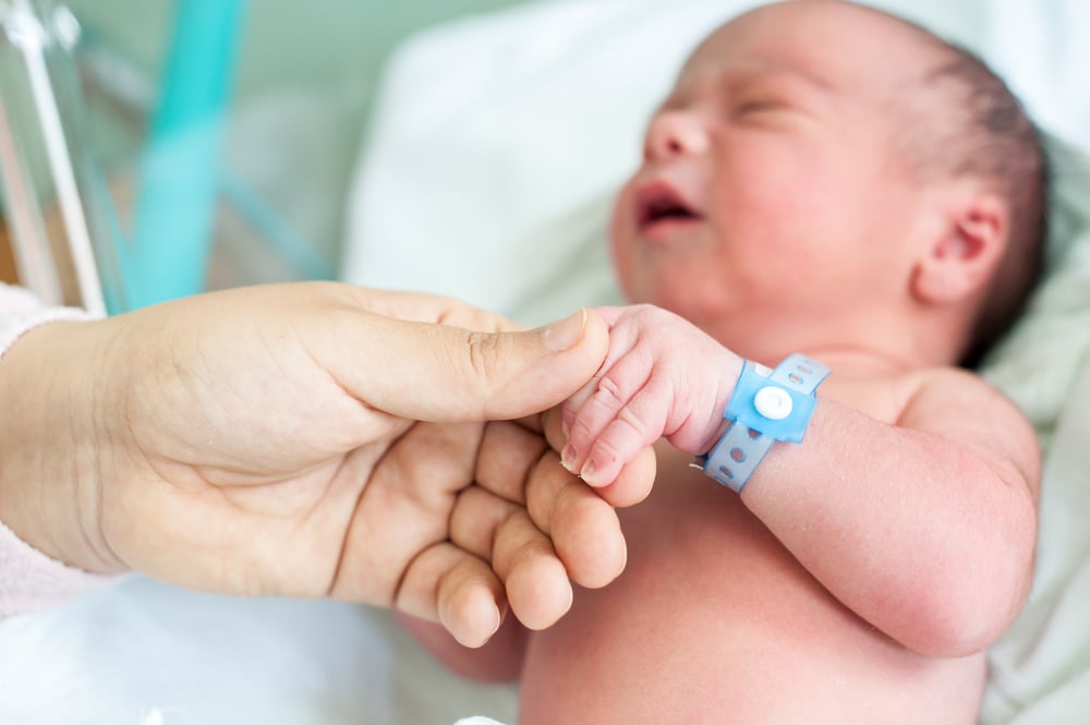 Newborn baby in hospital with identification bracelet tag name